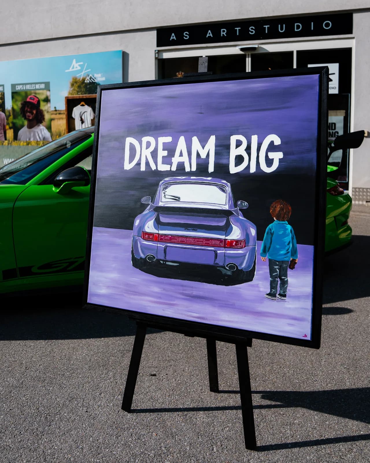 The painting “Dream Big”: a Porsche 911 at night in violet light, with a small child looking at it
