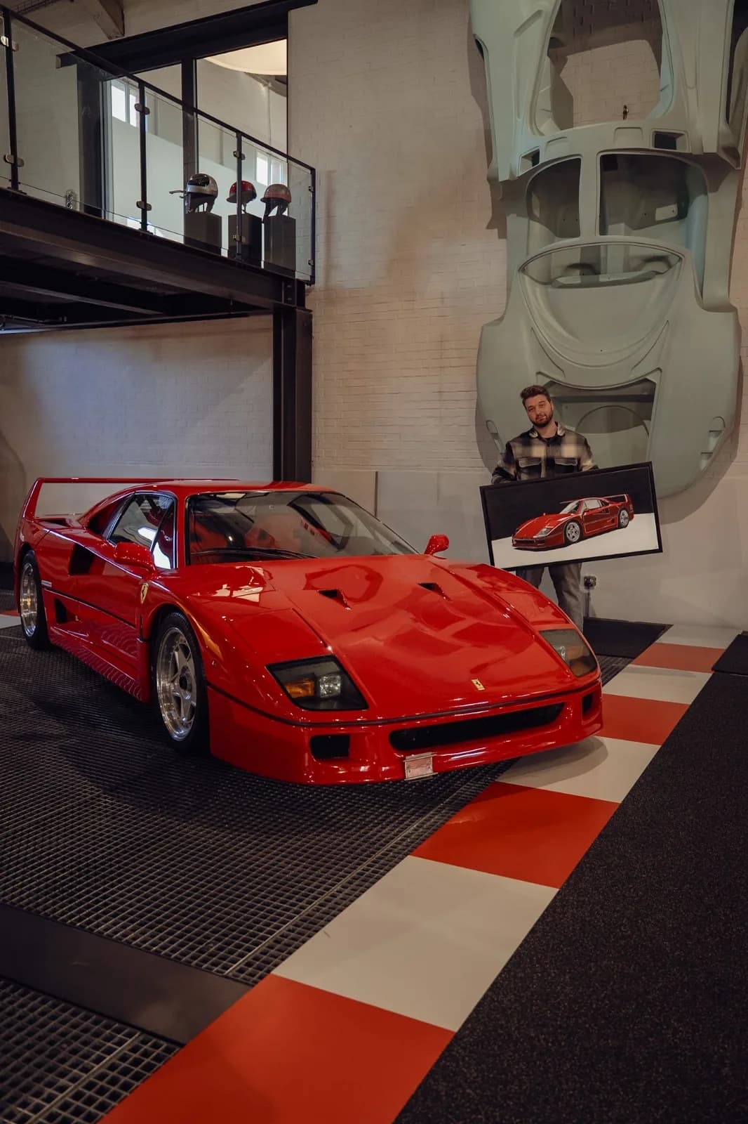 Andre Schwarzhans holding the Ferrari F40 painting next to a real Ferrari F40