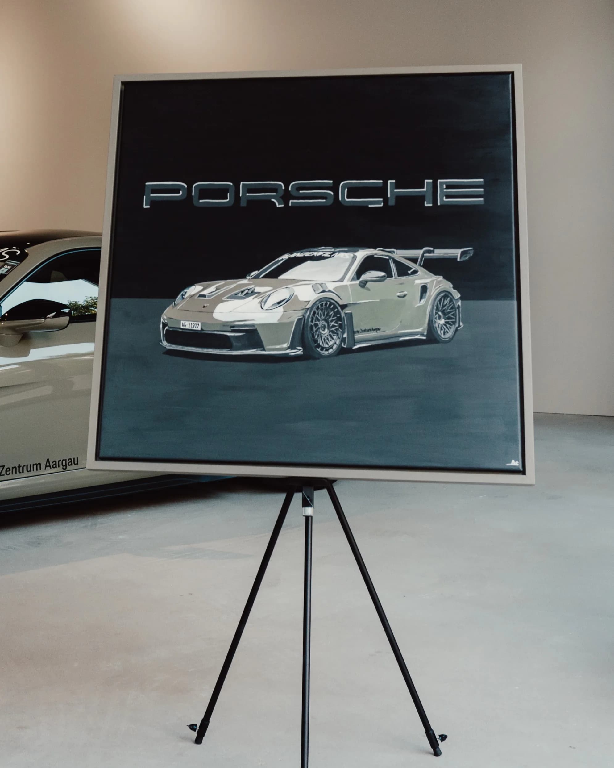 The finished GT3 RS painting on its easel: a Porsche 911 GT3 RS in Planzer livery under chrome PORSCHE lettering