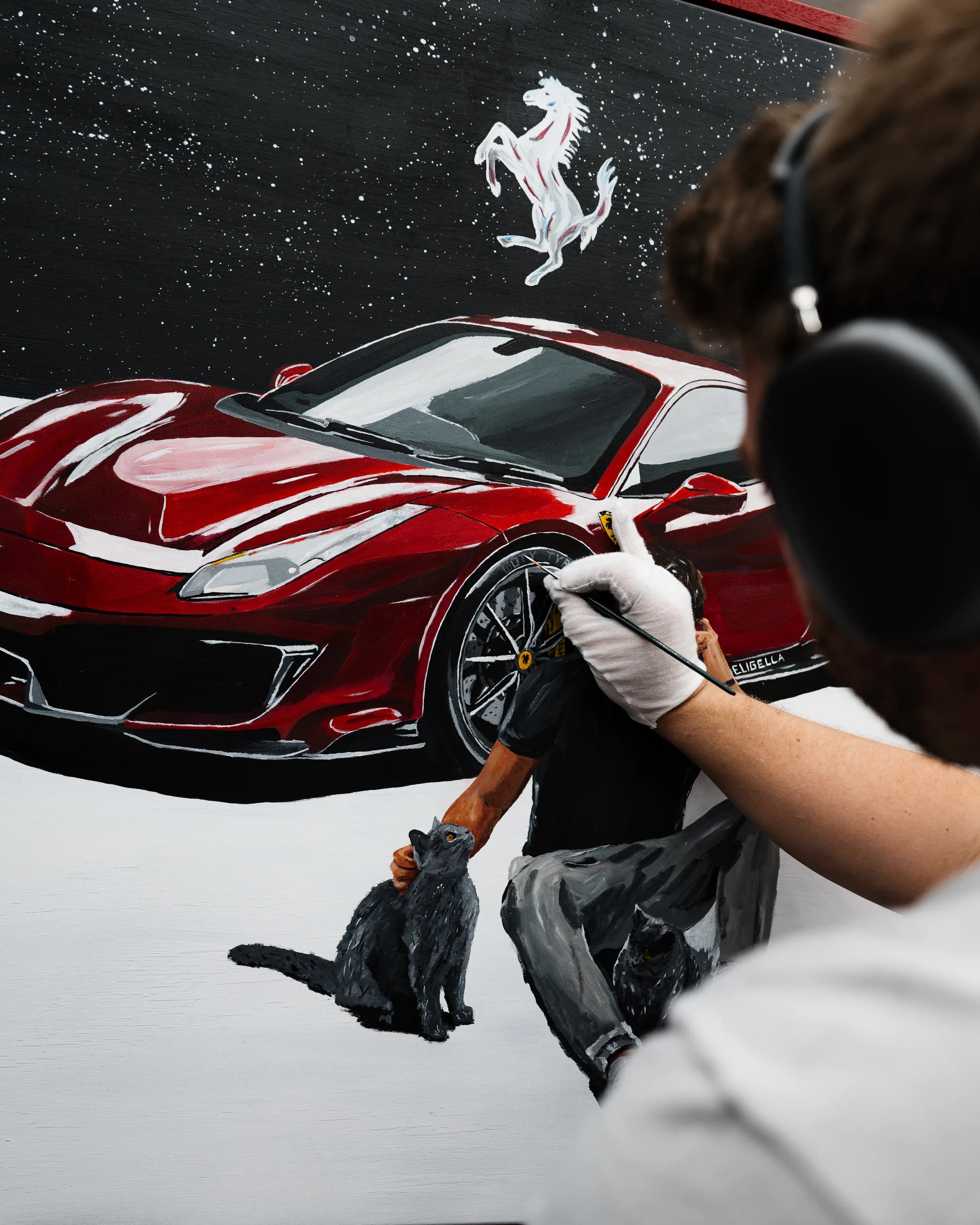 Close-up of Andre Schwarzhans painting the red Ferrari 488 Pista canvas