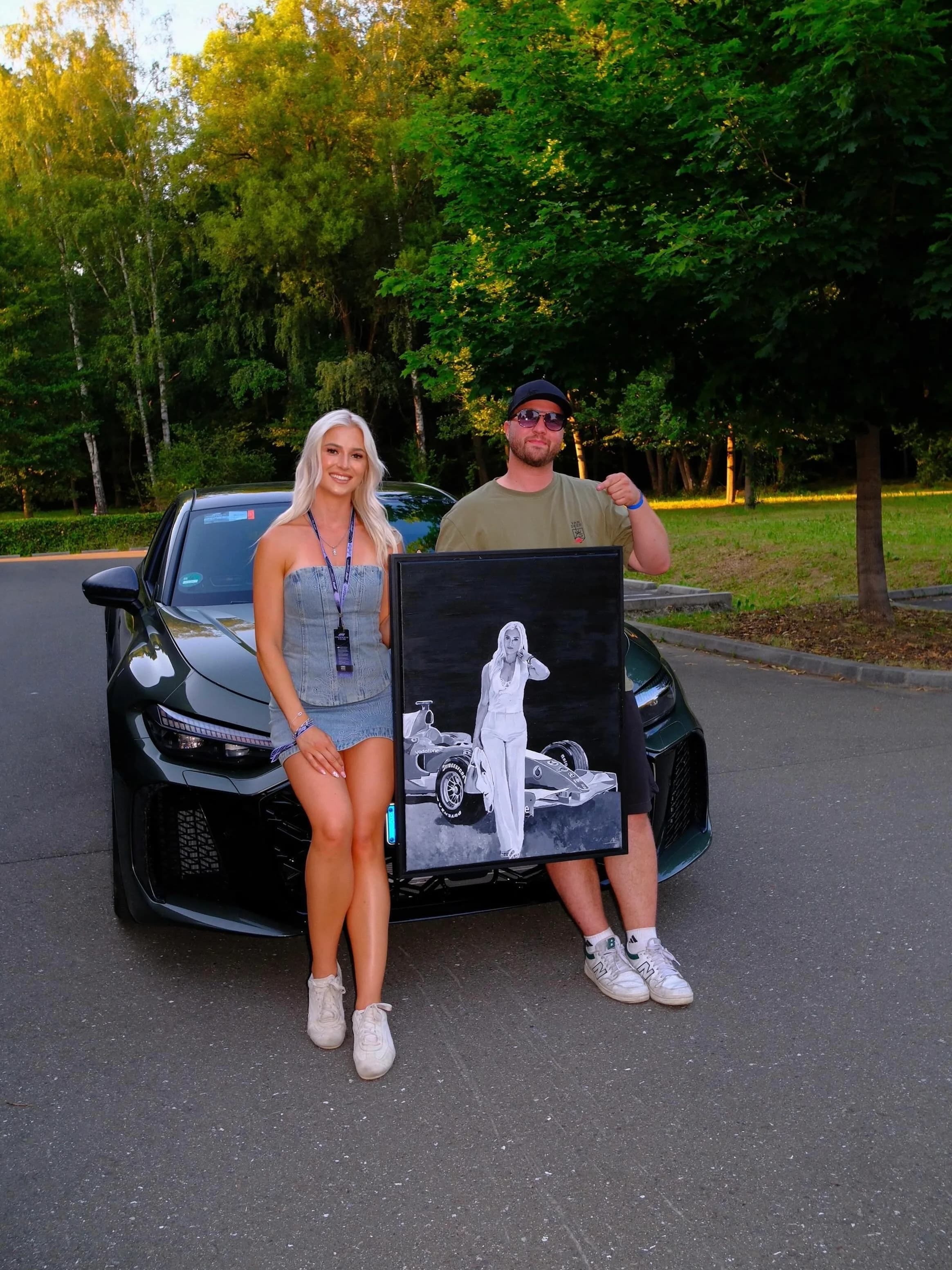 Laura Sommer and Andre Schwarzhans with the finished painting in front of an Audi RS 6