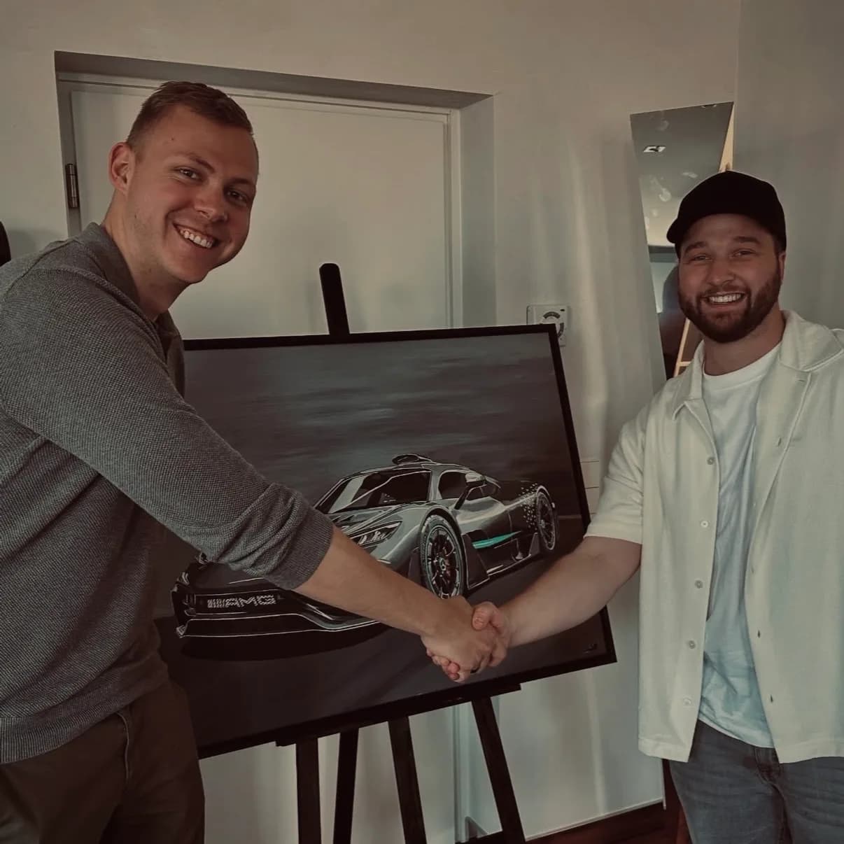 Handshake in front of the Mercedes-AMG One painting — start of the Motorworld collaboration