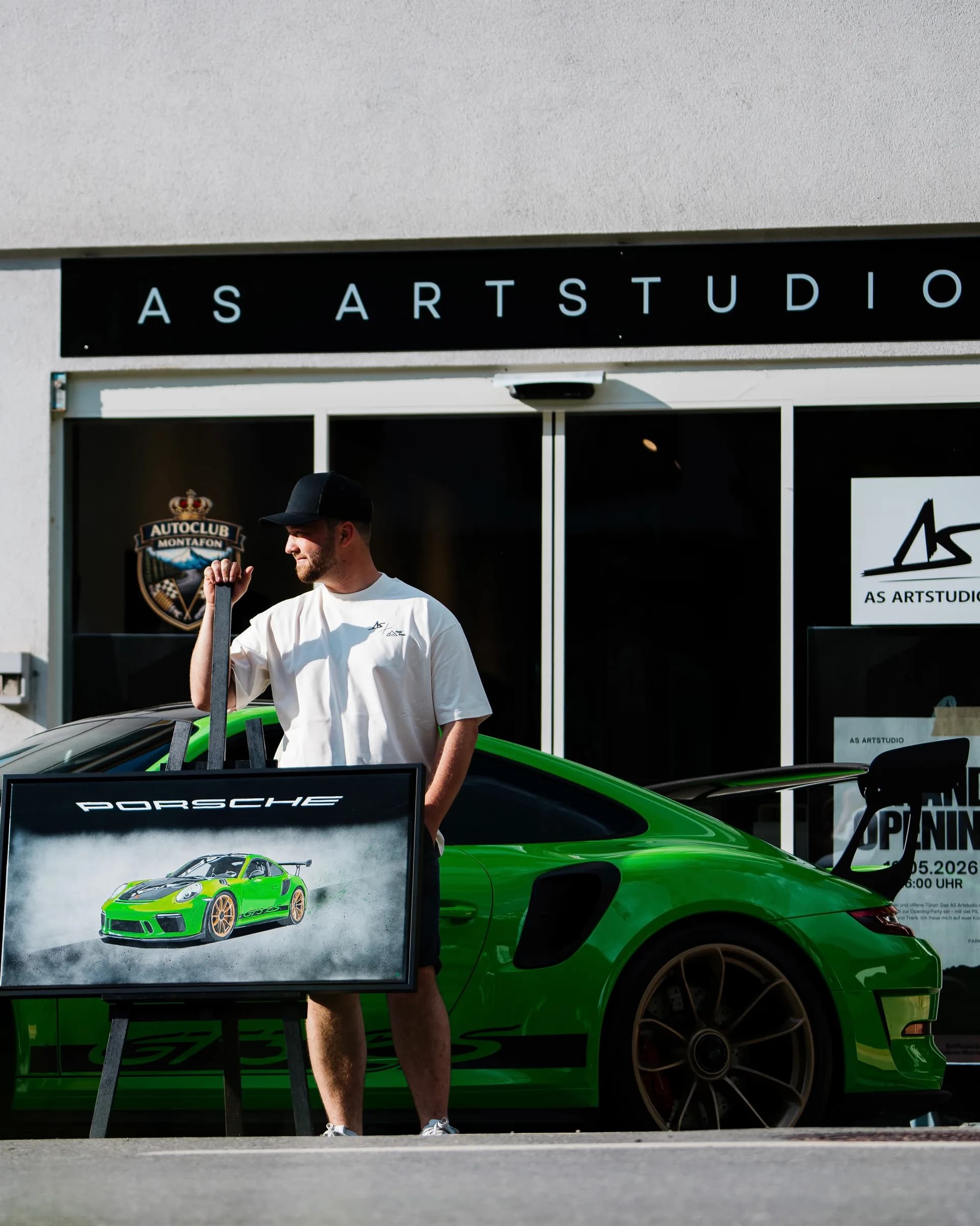 Andre Schwarzhans in front of the AS Artstudio at the grand opening with a green Porsche 911 GT3 RS
