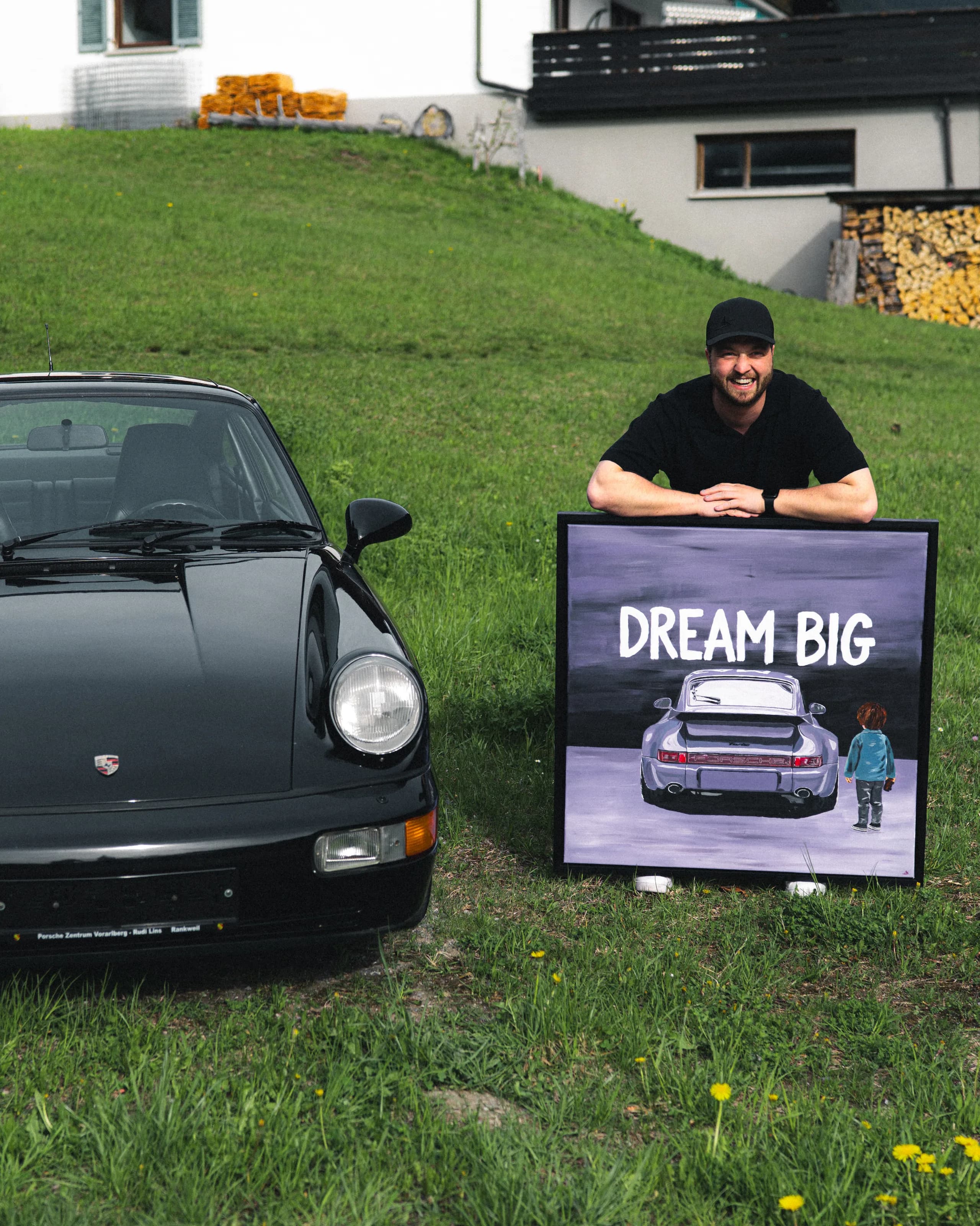Andre Schwarzhans leaning on the "Dream Big" Porsche 911 painting