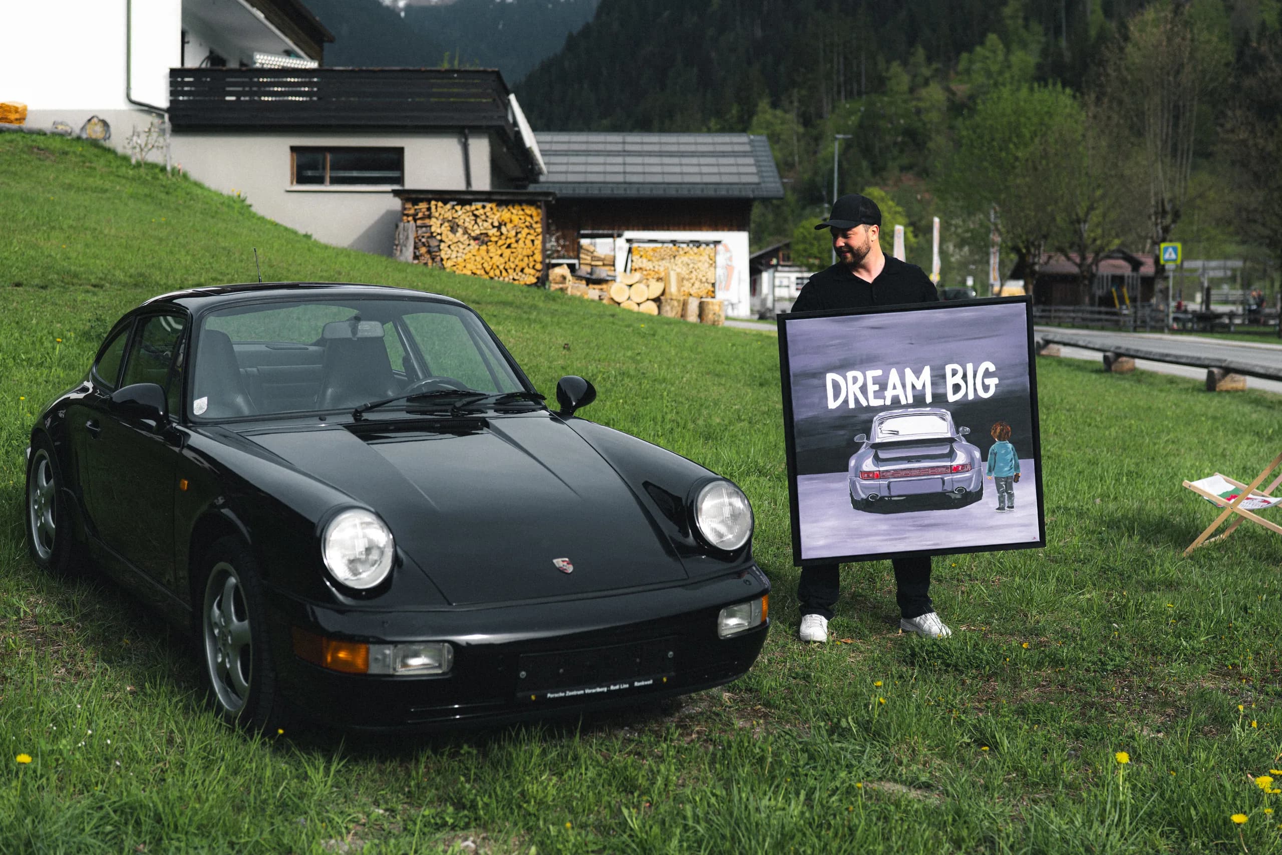 The "Dream Big" Porsche 911 painting next to a black Porsche 964